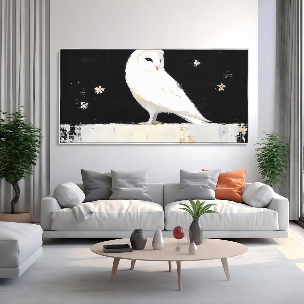 Tablou canvas cu tablou canvas cu bufnita alba, in rama de aluminiu argintiu, pe perete intr-un living